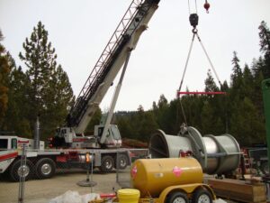 A crane lifting a metal tube